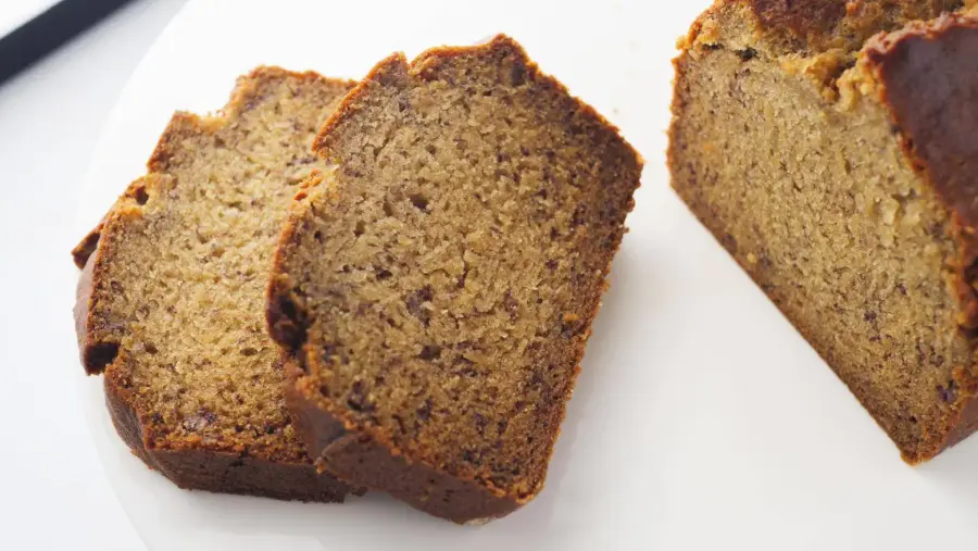 Slices of moist homemade banana bread on a white plate.
