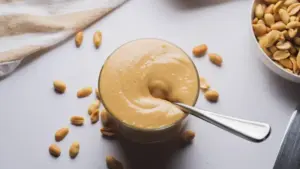 Honey Roasted Peanut Butter in a glass jar with a spoon