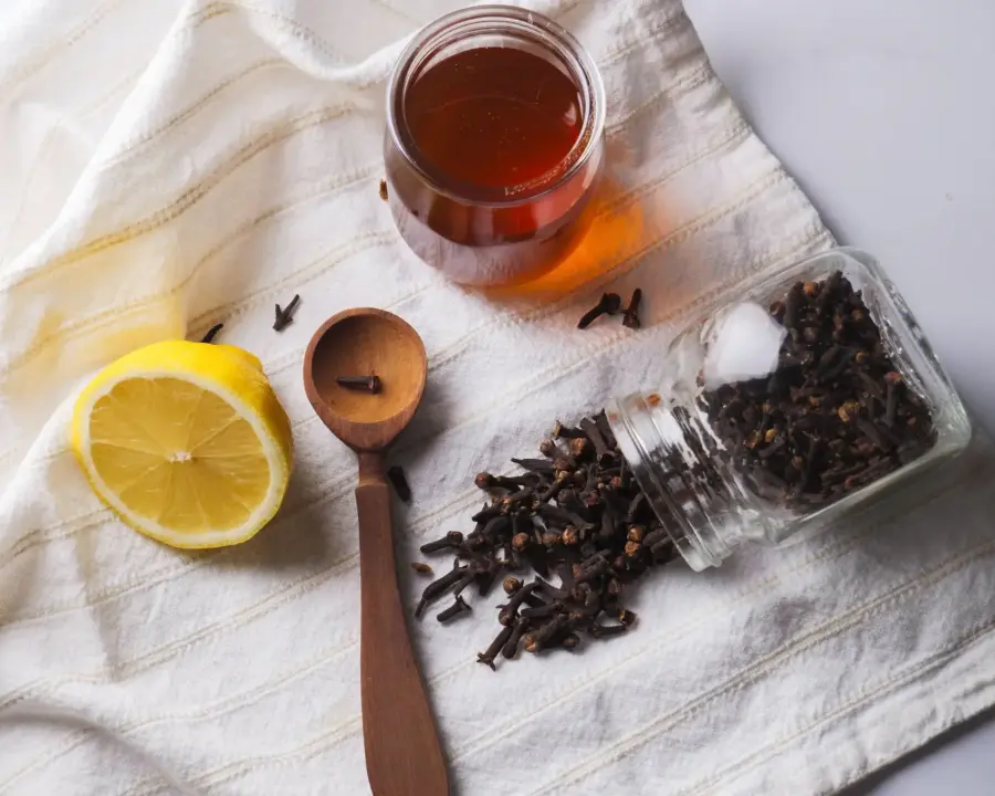 Clove Tea Recipe essentials on top of a kitchen counter
