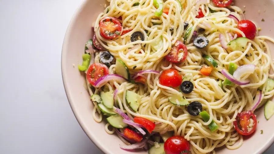 Spaghetti Pasta salad with cherry tomatoes, olives, cucumbers, cheese, bell peppersand red onion