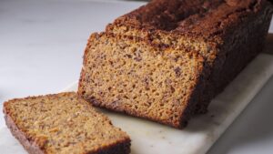 Sliced banana bread with almond flour on a marble surface.