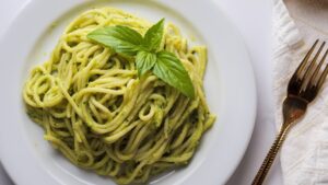 Spaghetti with avocado sauce on a white plate.