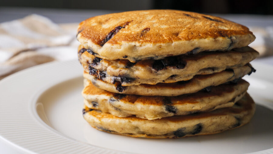 Fluffy Chocolate Chip Banana Pancakes on a white serving plate