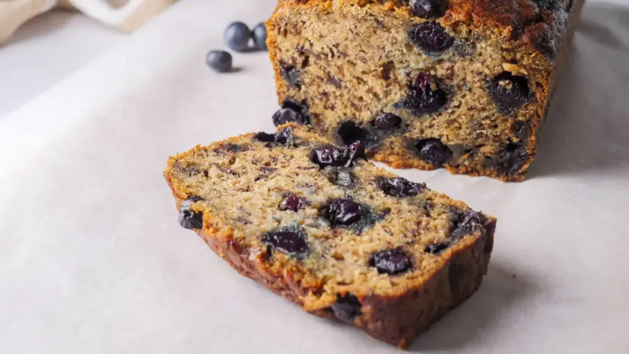 Blueberry banana bread slices on parchment paper.