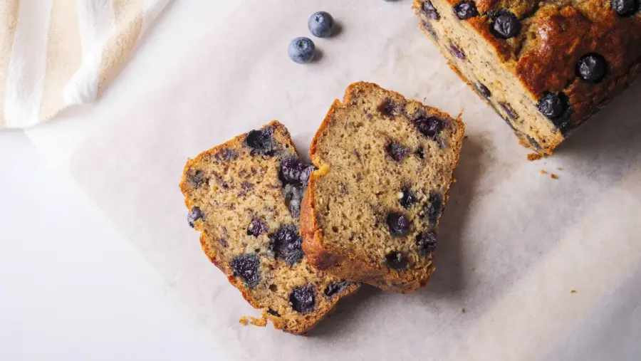 Blueberry banana bread slices on parchment paper.