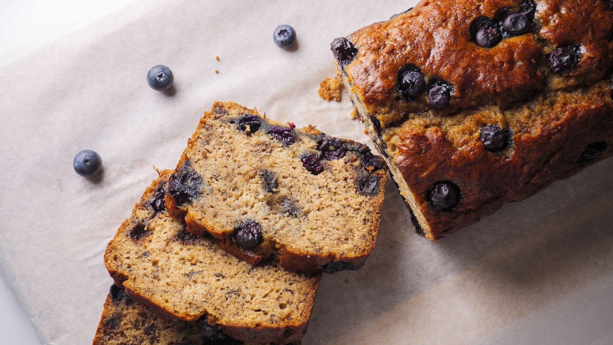 Blueberry banana bread slices on parchment paper.