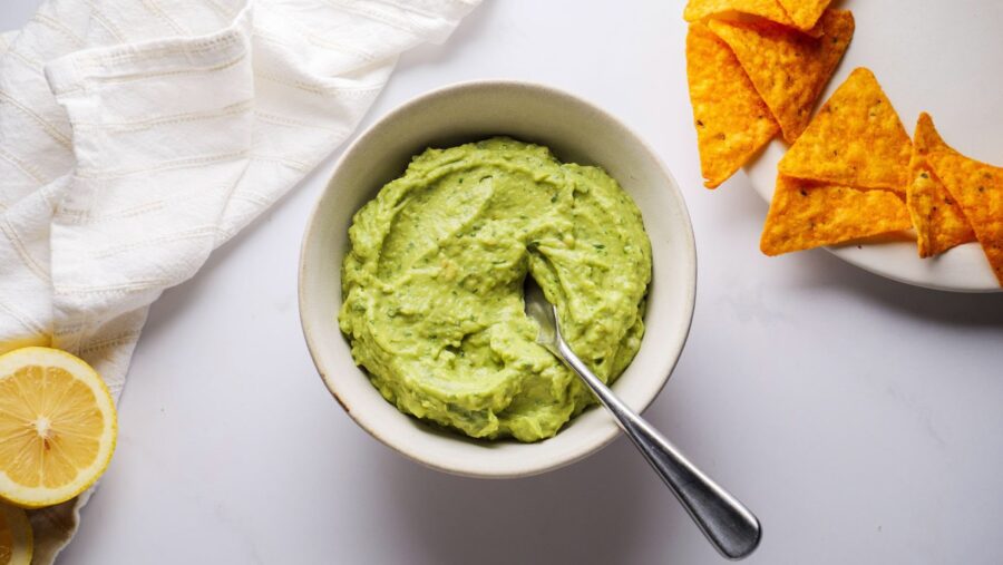 Creamy Avocado pasta Sauce served with Nachos garnished with lemon slices.