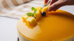 No Bake Mango cheesecake with fresh garnish being decorated.