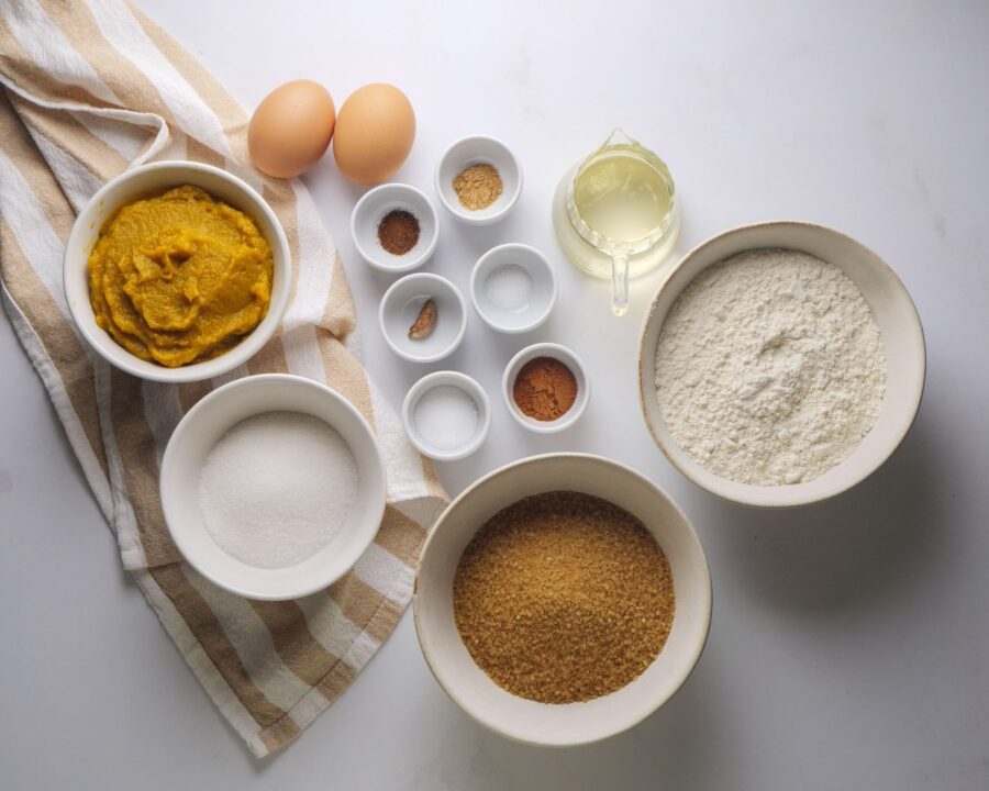 Baking ingredients for a pumpkin bread recipe laid out on a table.