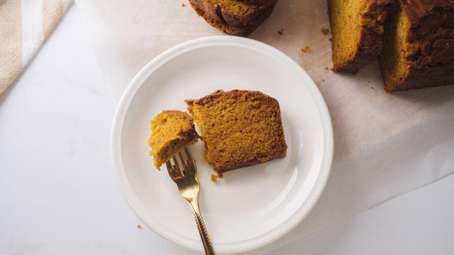 Homemade pumpkin bread served in a white plate with a fork