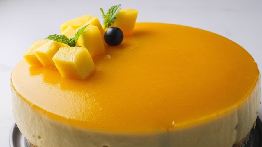 No-bake Mango cheesecake with fresh cubes and mint garnish.