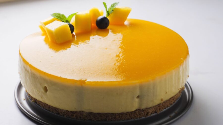 easy no bake Mango cheesecake with fresh cubes and mint garnish.
