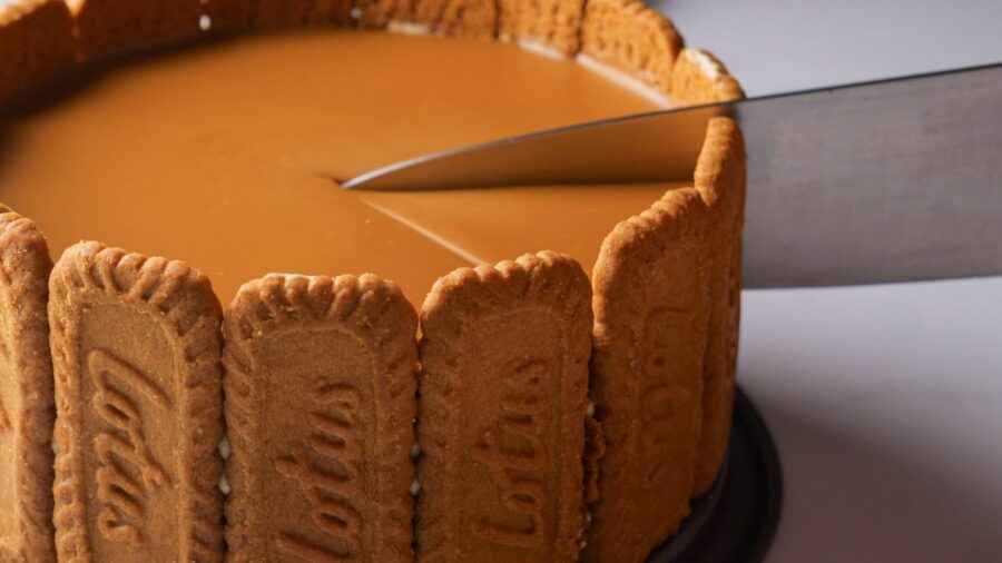 lotus Biscof Cheesecake with biscuit edge being sliced.