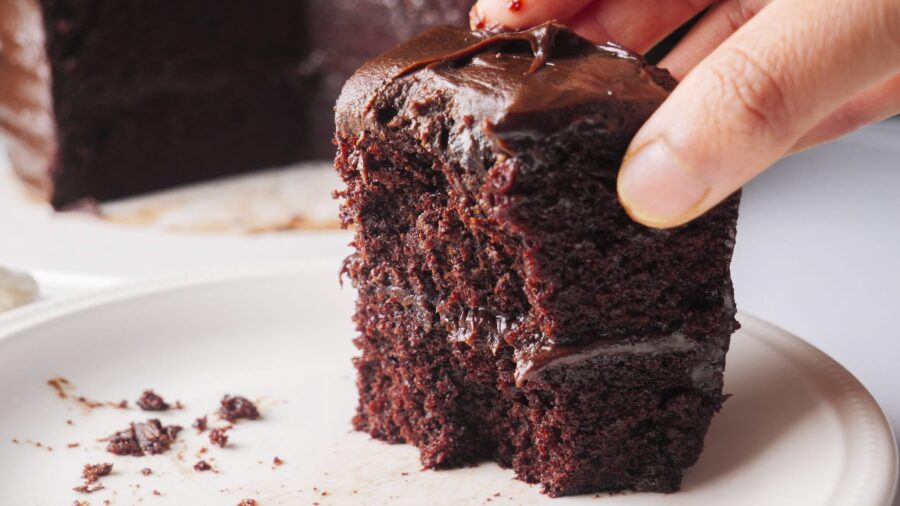 Matilda's chocolate cake slice with rich frosting on a white plate.