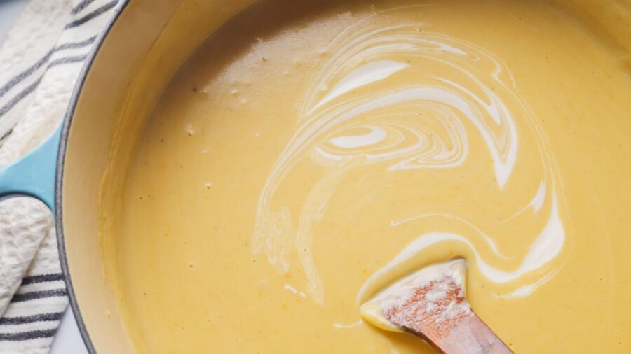 Creamy Potato Soup in a pot with sour cream swirl.