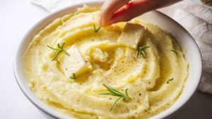 Creamy garlic mashed potatoes with butter and herbs in a bowl.