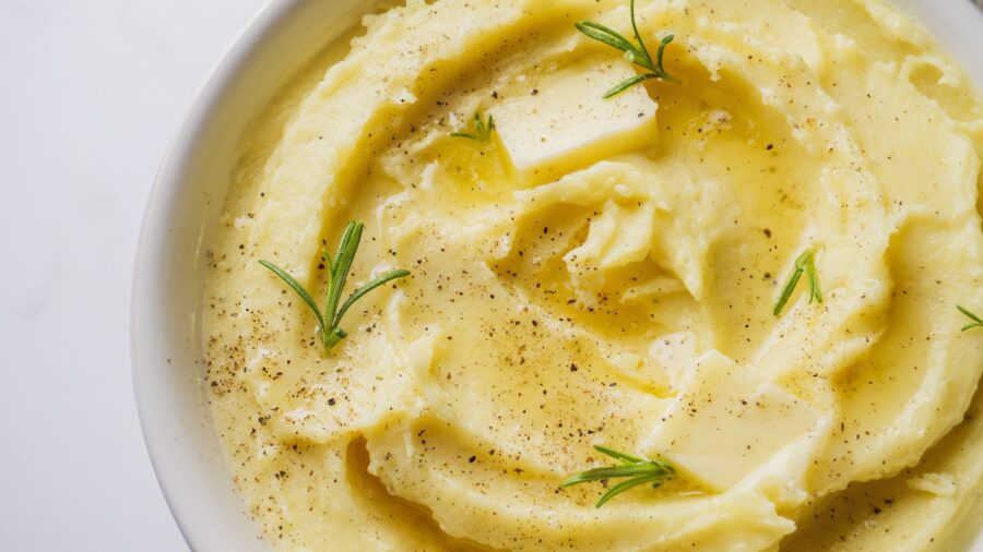 mashed potatoes with garlic, butter, and rosemary garnish.