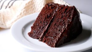 Slice of rich Matilda's chocolate cake on a white plate.