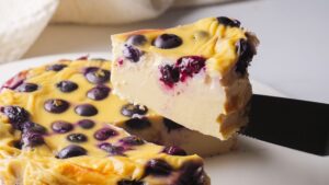 Blueberry Yogurt Cake sliced with blueberries on a knife.