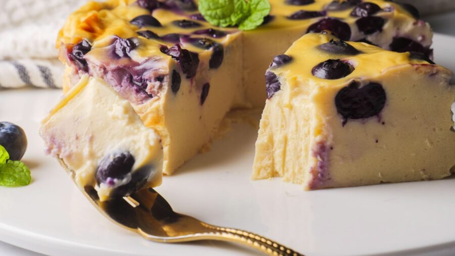 Blueberry Greek Yogurt Cake sliced on a fork, garnished with mint leaves.