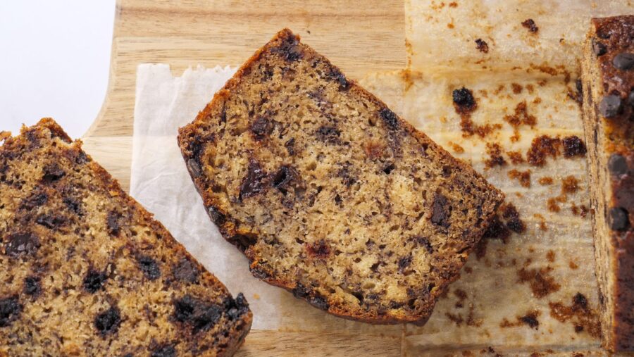 Banana chocolate chip bread slices on a wooden board.