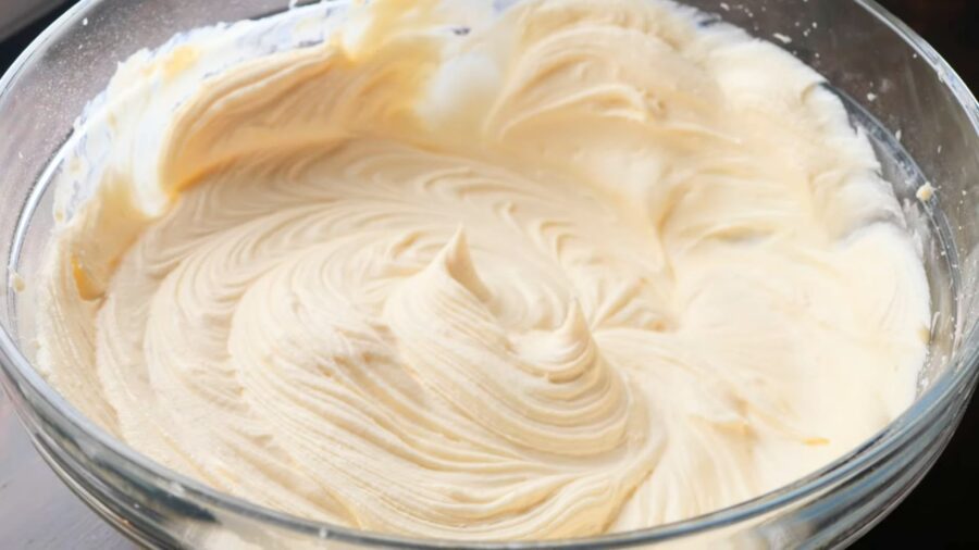 Cream cheese frosting in a glass bowl.