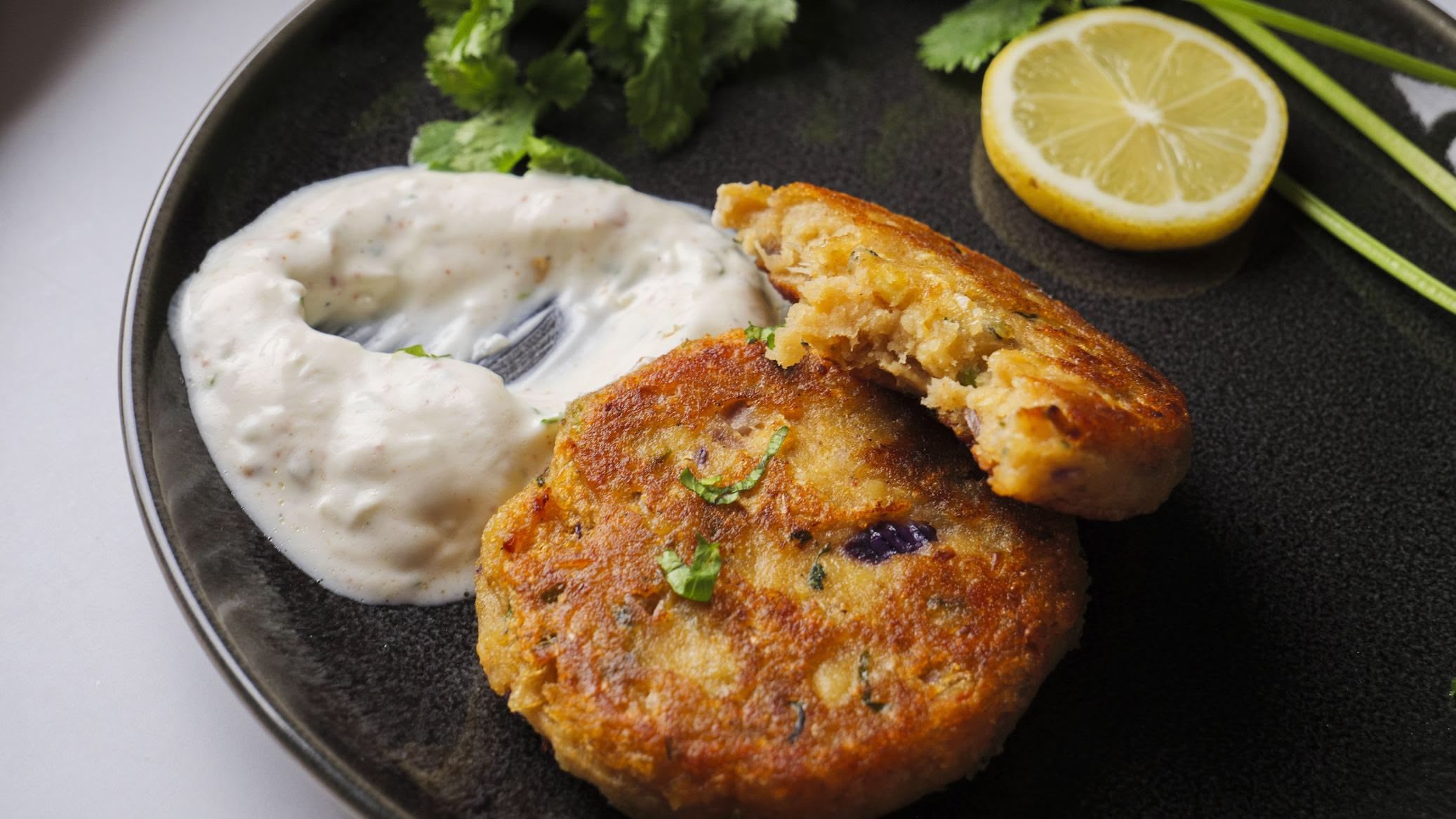 Crispy vegetarian chickpea patties with creamy dip and lemon slice.