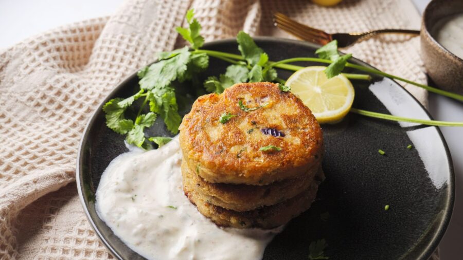 Golden chickpea fritters with cilantro and lemon garnish.