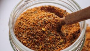 Jar of Jamaican Jerk Seasoning with a wooden spoon.