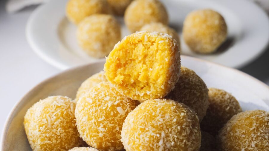 Delicious coconut-covered mango truffles in a bowl.