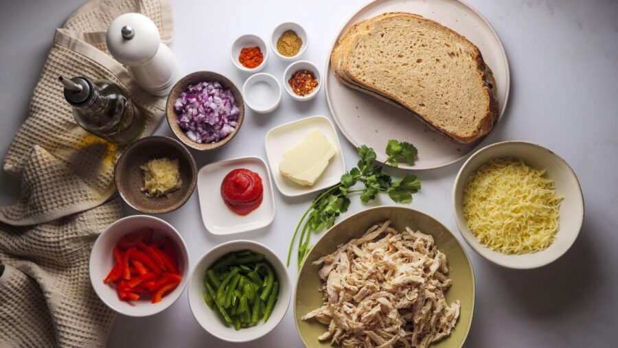 Ingredients for a chicken sandwich recipe are laid out on a table.