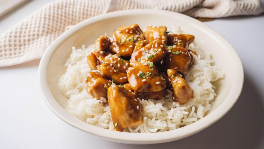 Teriyaki chicken on rice garnished with sesame seeds.