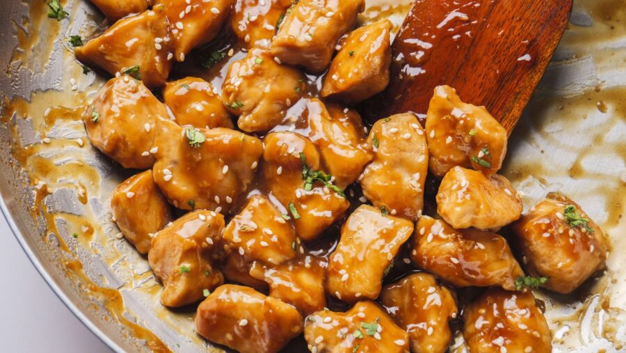 Sticky, sweet, and savory Teriyaki chicken bites with sesame seeds in a skillet.