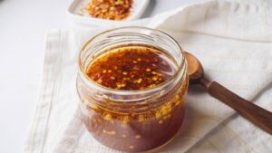 Jar of homemade Hot Honey with a wooden spoon.