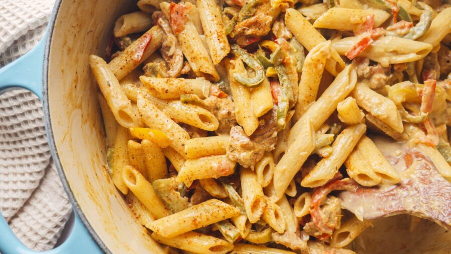 Creamy jerk seasoning rasta pasta with vegetables in a pot