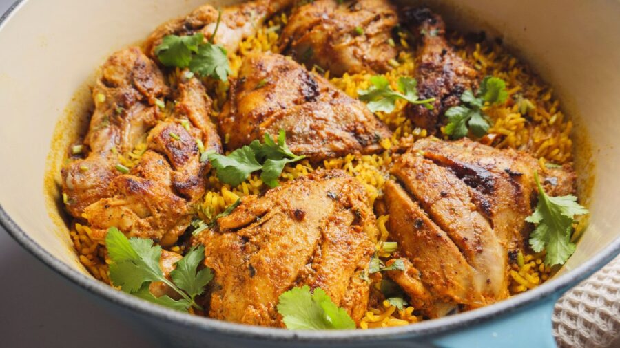 Tandoori chicken with rice and cilantro in a pot.