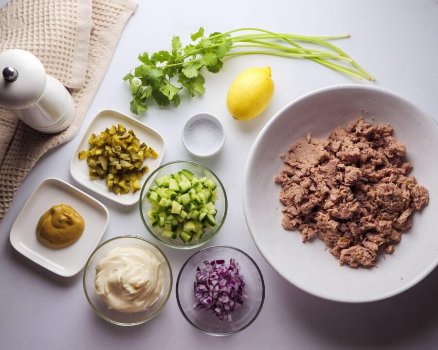 Tuna salad ingredients: tuna, cucumber, mustard, herbs, lemon.
