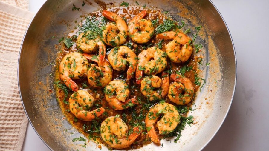 shrimp scampi without wine in a pan garnished with fresh herbs.