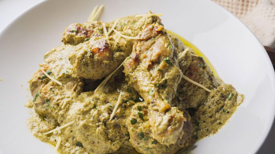 Delicious Afghani chicken curry with herbs and spices in a white dish.