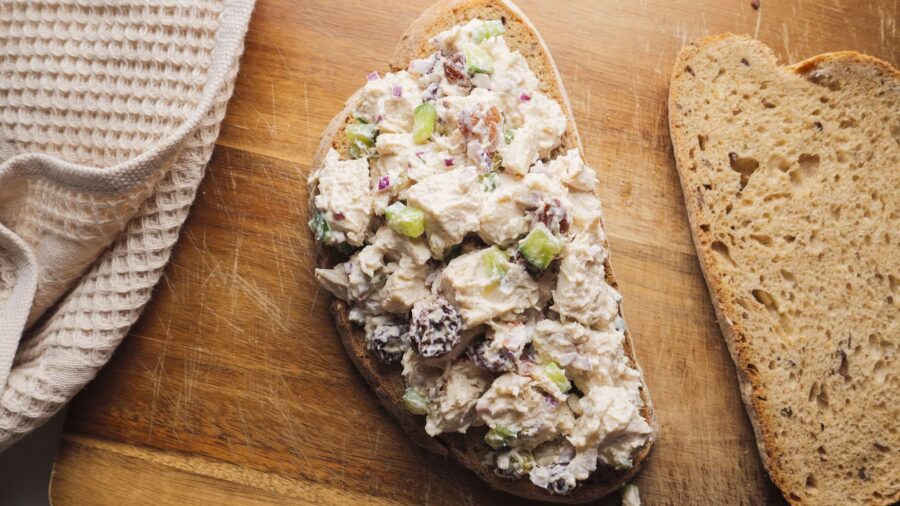 Homemade Chicken salad sandwich on a wooden board.