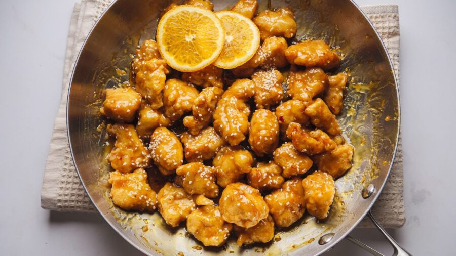 Orange chicken with sesame in a skillet.