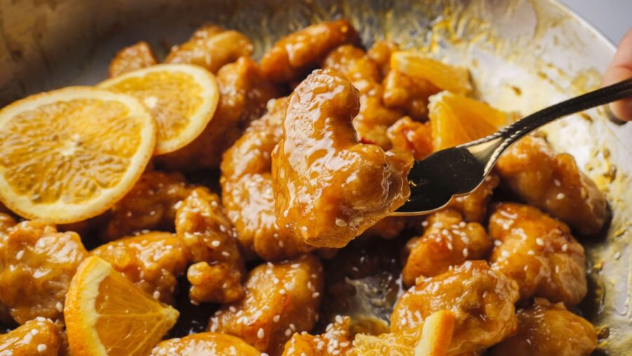 Zesty orange chicken with sesame seeds and orange slices.