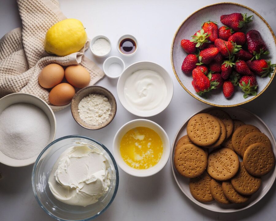 Ingredients for strawberry cheesecake recipe placed on a kitchen counter