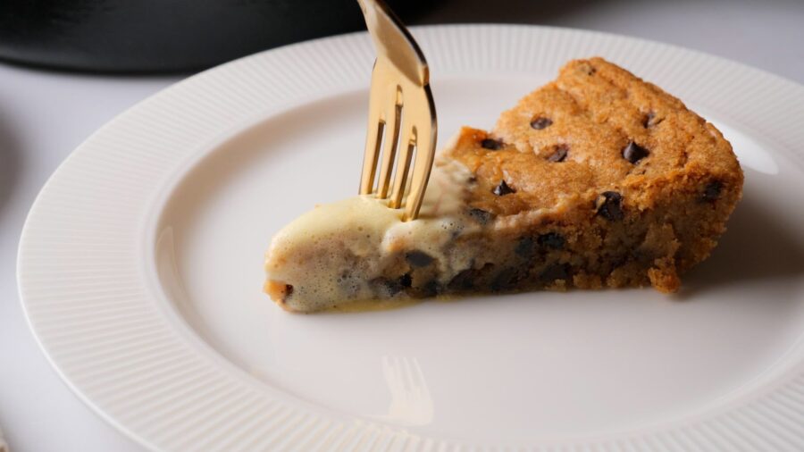 Eating chocolate chip cookie pie slice with fork.