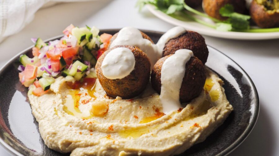 Plate of falafel with hummus, tahini, and salad.