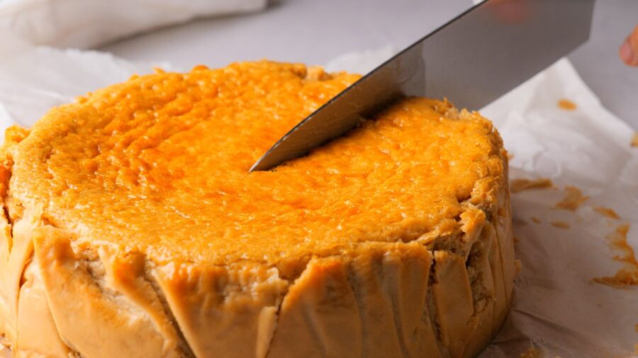 Knife slicing into a creamy coffee cheesecake in a blender