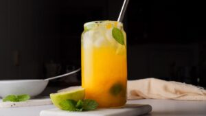 Refreshing mango mojito with mint and lime on marble.