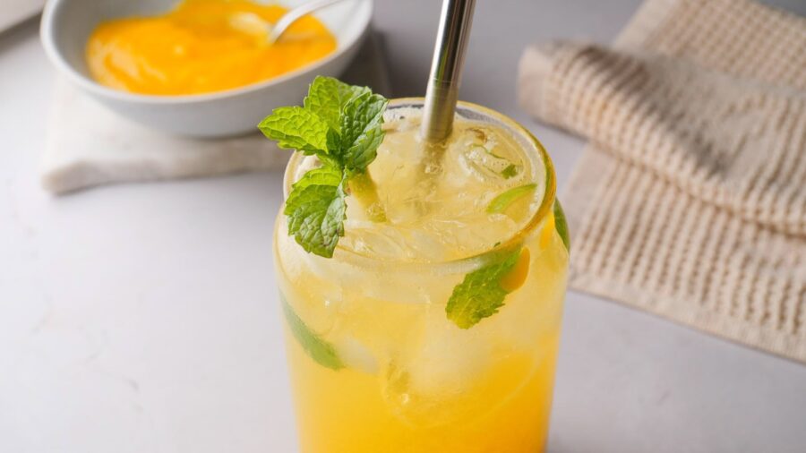Refreshing mango mint drink in a glass jar with ice.