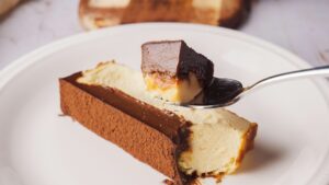 Iceberg Basque Cheesecake slice on a white plate, and a little portion is on a spoon
